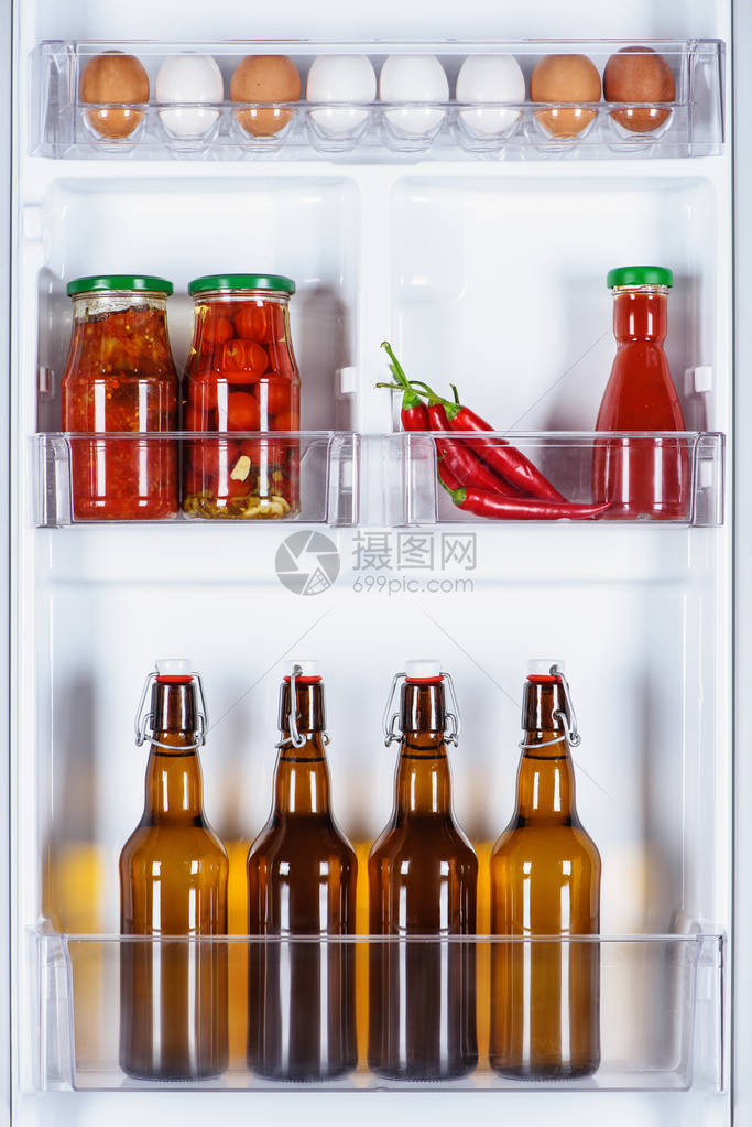 冰箱里的鸡蛋和玻璃瓶啤酒图片