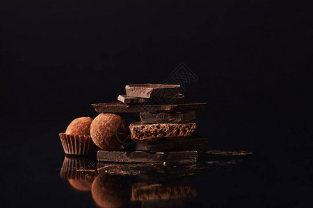 黑色松露和巧克力棒排列的特写视图图片