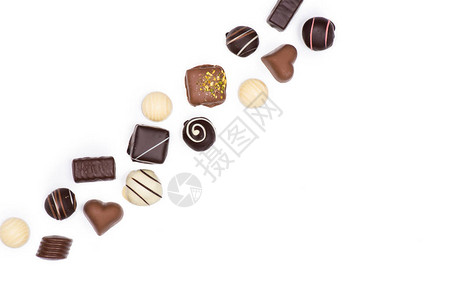 各种美巧克力糖果的顶端视图其中白色是孤背景图片