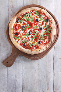 新鲜出炉的披萨配橄榄和意大利腊肠图片