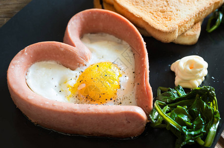 用蛋黄酱和蔬菜烤锅上的煎鸡蛋在心图片