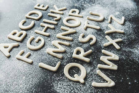 饼干面团的特写用糖粉的字母形背景图片