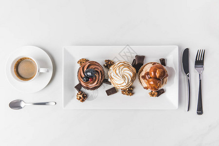 各种纸杯蛋糕咖啡和餐具的顶端观景白图片
