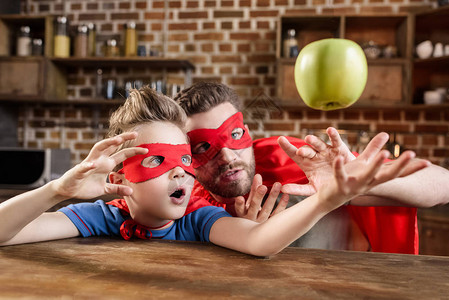 英雄出少年父亲和儿子穿着红色超级英雄背景