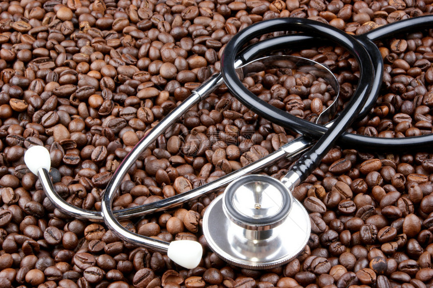 新鲜烘焙的咖啡豆和听诊器图片