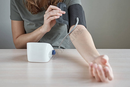 女人自己用数字压力监视器测量血压医疗保图片