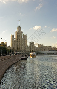 莫斯科市中心的日出高楼和河上游艇航行的图片