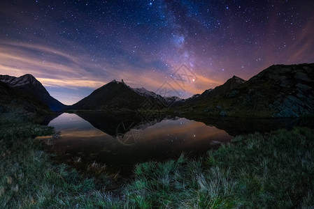 银河弧和星空在阿尔卑斯山脉高海拔的湖上反射而来的极佳美图片