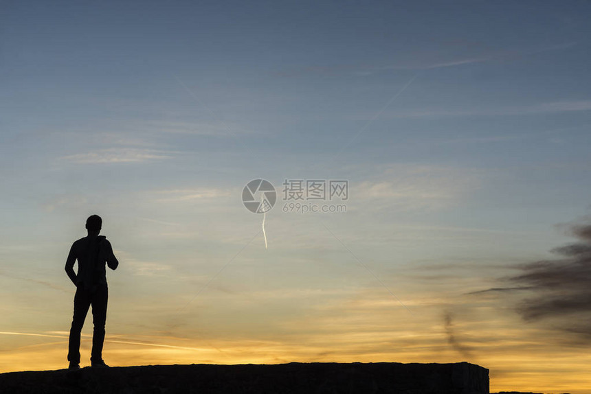 站在户外的人对着色彩繁多的日出和复制图片