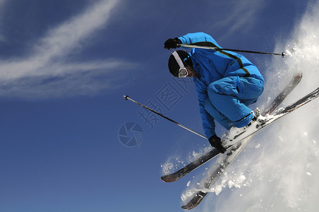 滑雪者在深蓝色的天空下与跨越的滑图片