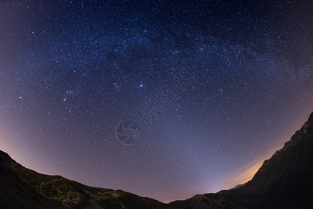 天狼星星空和银河系在阿尔卑斯山脉上通过鱼眼镜头捕捉背景