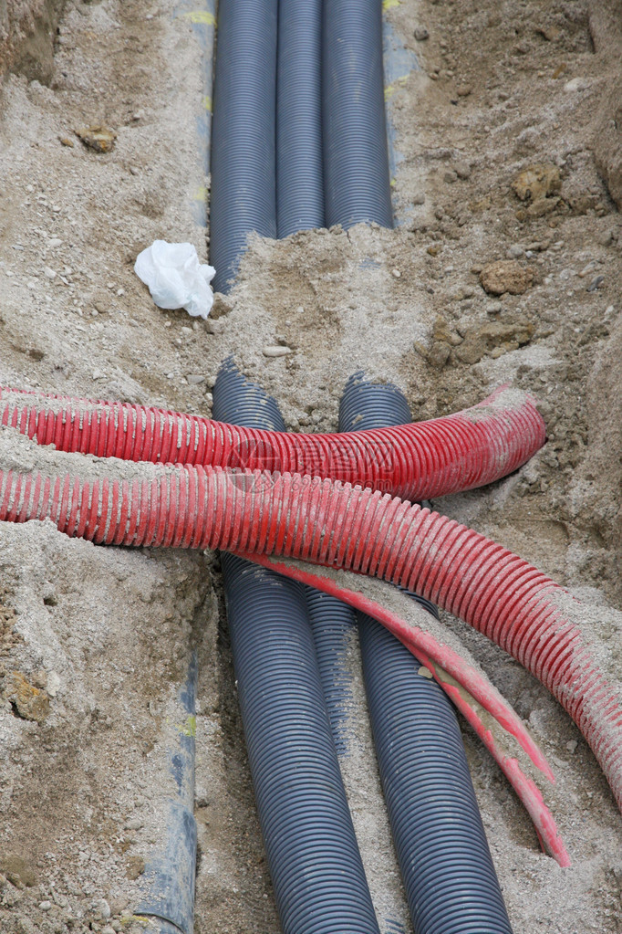 在铺设煤气管道电缆和水管的建筑工地进行挖掘的详细节图片