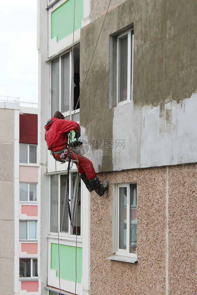 专家在高处的建筑墙壁变暖了上面有很多古老图片