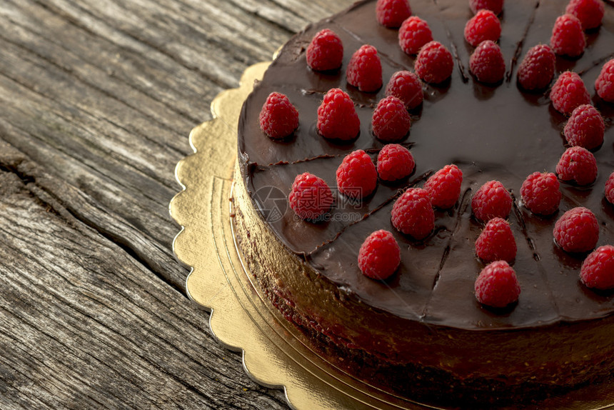 用覆盆子装饰的美味生巧克力蛋糕的俯视图邀请您沉迷于甜蜜的诱惑图片