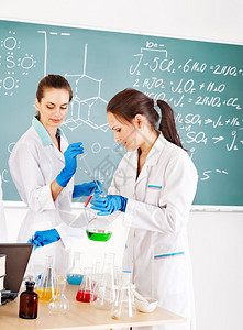 有烧瓶的女化学生在教室里图片