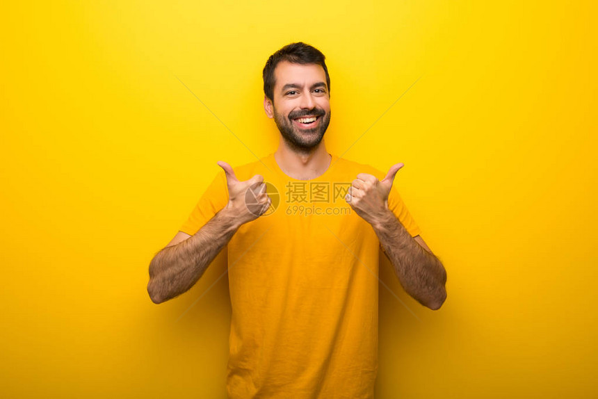 男人用孤立的青黄色以双手和微笑举图片