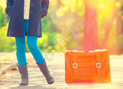 带着手提箱的少女在秋天户外图片