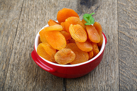木背景上碗里的甜杏干背景图片