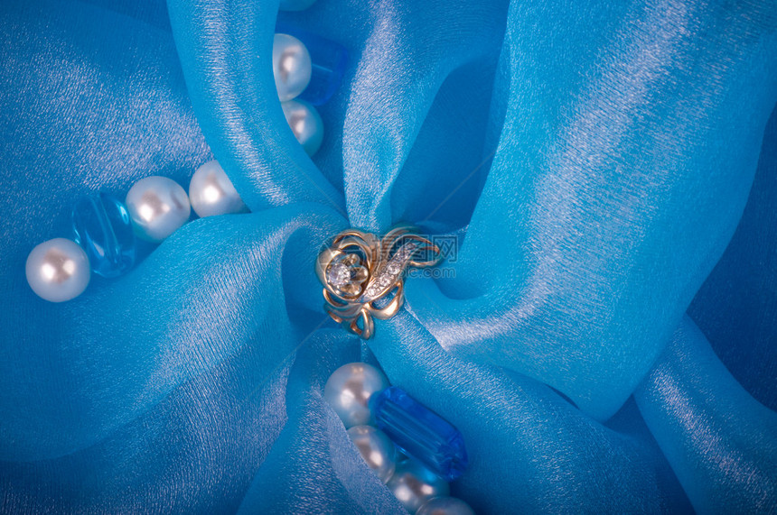 蓝色背景上的金色珠宝戒指图片