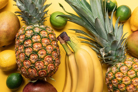 整个成熟香蕉菠萝柑橘水果和黄底芒图片