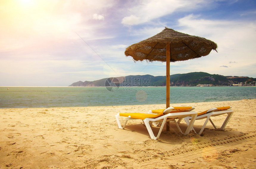 在沙滩上有金沙的滩上带遮太阳和甲板椅的多姿图片