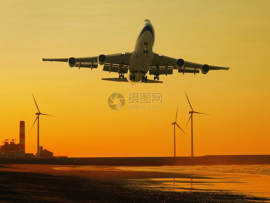 飞机和风力发电机在海岸图片