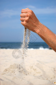 从男人手中落下的沙子的概念照片图片