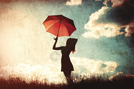 带雨伞的年轻女子在天空图片