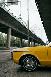 桥下黄色复古老爷车侧视图图片