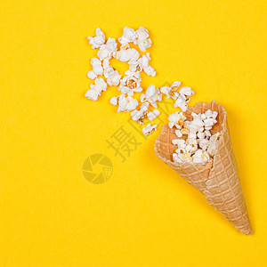 黄色背景的冰淇淋甜筒里的爆米图片