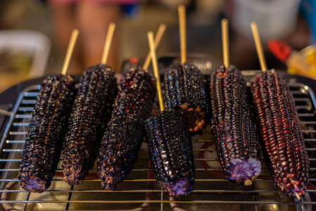 在泰国街头食品市场或泰国餐馆出售的烧烤或灰状紫色玉米黑图片