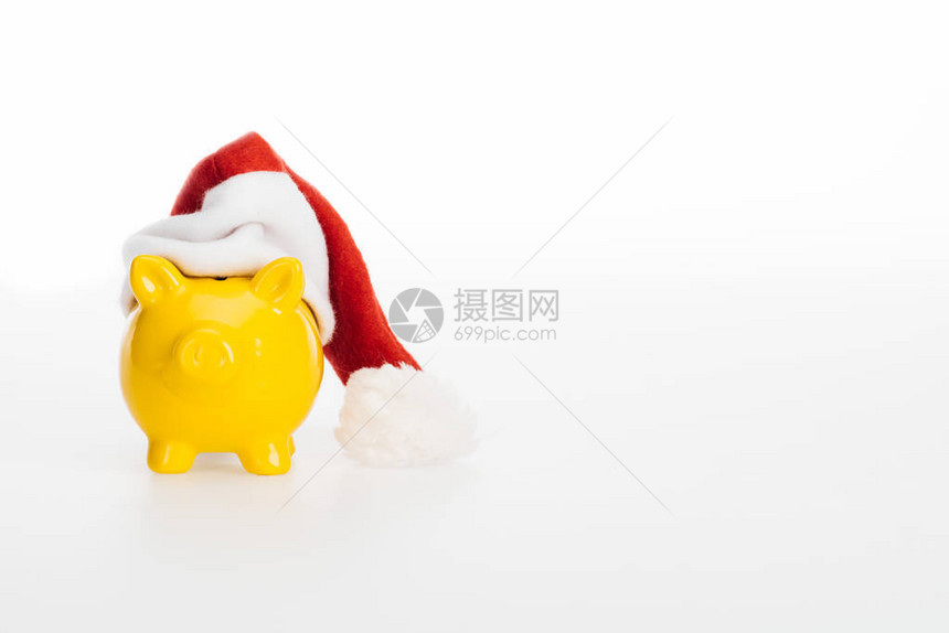 在白色隔离的圣诞老人帽子的黄色存钱罐图片