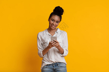 积极的黑人女孩手里拿着智能手机图片