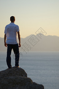 人站在岩石上望着大海图片