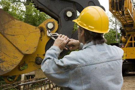 身戴黄硬帽的重型设备机械技工用手工图片