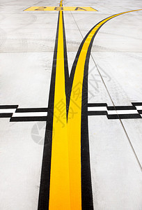 混凝土上的黑色和黄色机场标记的图片背景图片