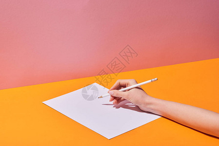 黄桌和粉红背景纸面上写字的妇图片