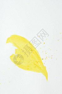 白色纸上带有飞溅的黄色抽象水彩笔画背景图片