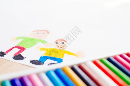 五颜六色的蜡笔油蜡笔和儿童画的父亲和儿子背景图片
