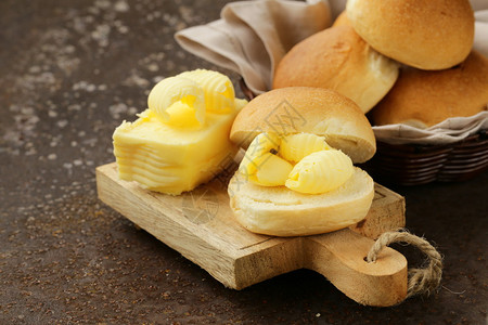早餐用新鲜面包上的黄色乳制品黄油图片