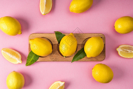 粉红色背景木板上新鲜黄色柠檬的顶视图图片