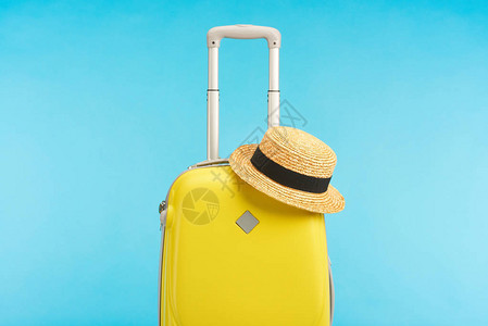 黄色旅行袋上面有草帽图片