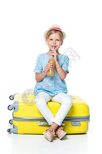 儿童饮酒坐在黄色行李中白背景图片