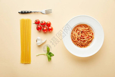 面条和番茄酱在叉口附近的盘子上图片