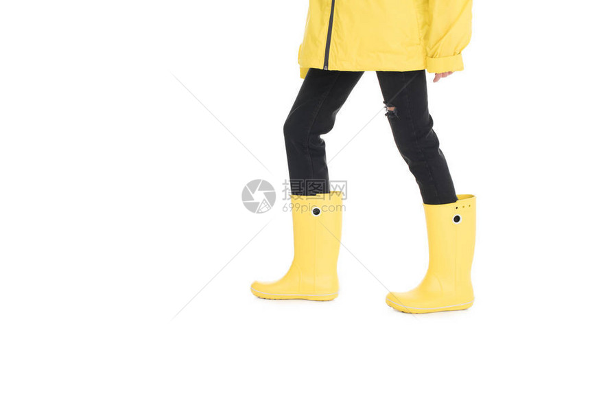 女在黄色雨衣和白色孤立的雨靴图片