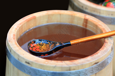 木桶用蜂蜜和木勺背景图片