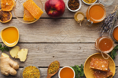 蜂蜜品种蜂蜜碗蜂窝花粉碗坚果生姜薄荷和干橙的框架甜美的背景图片