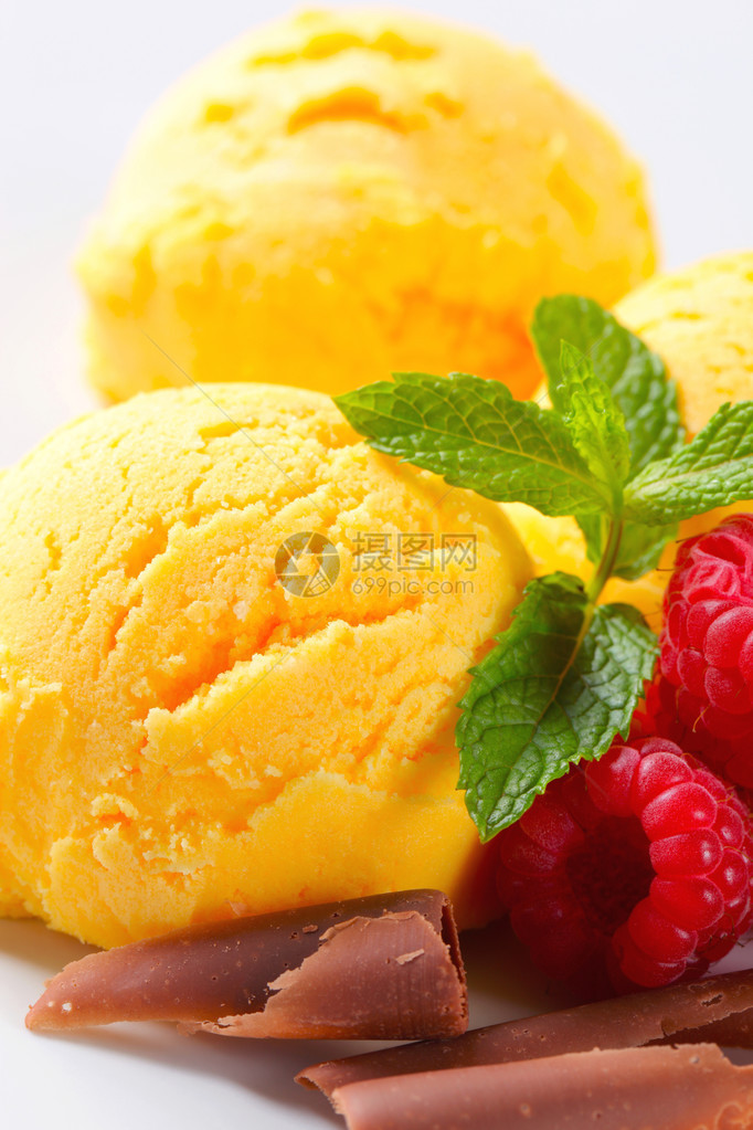 一勺黄色冰淇淋配覆盆子和巧克力卷图片