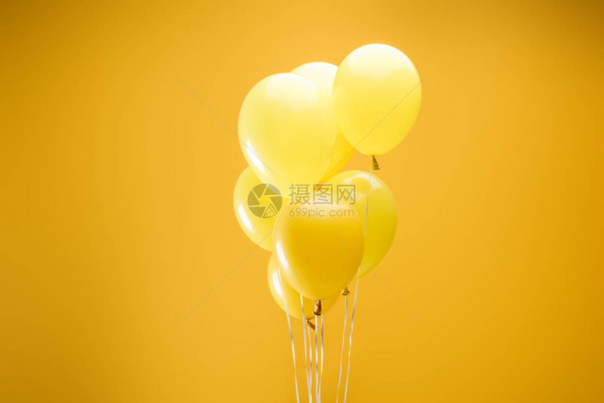黄色背景上的彩色简约装饰气球图片