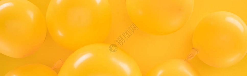 黄色背景上黄色气球的全景拍摄背景图片